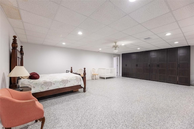 bedroom with ceiling fan and a drop ceiling