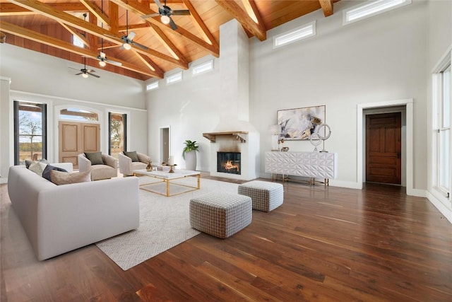 living room with a large fireplace, dark hardwood / wood-style floors, high vaulted ceiling, and wooden ceiling