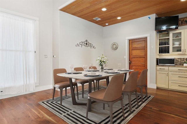 dining space with dark hardwood / wood-style flooring and wooden ceiling