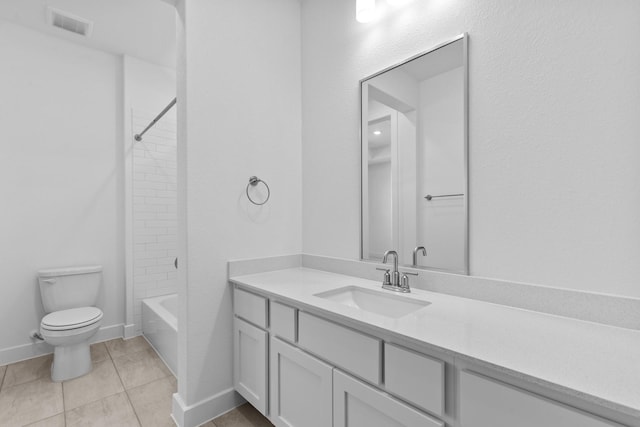 full bathroom with tile patterned flooring, vanity, tiled shower / bath, and toilet