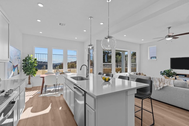 kitchen featuring white cabinetry, hanging light fixtures, light hardwood / wood-style floors, and an island with sink