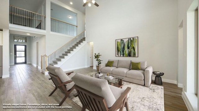 1024 Lariat Loop, Liberty Hill, TX 78642 - living room featuring a high ceiling, stairway, baseboards, a ceiling fan, and wood finished floors