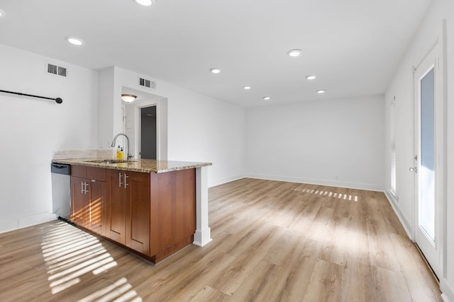 bar with dishwasher, sink, light hardwood / wood-style floors, and light stone counters