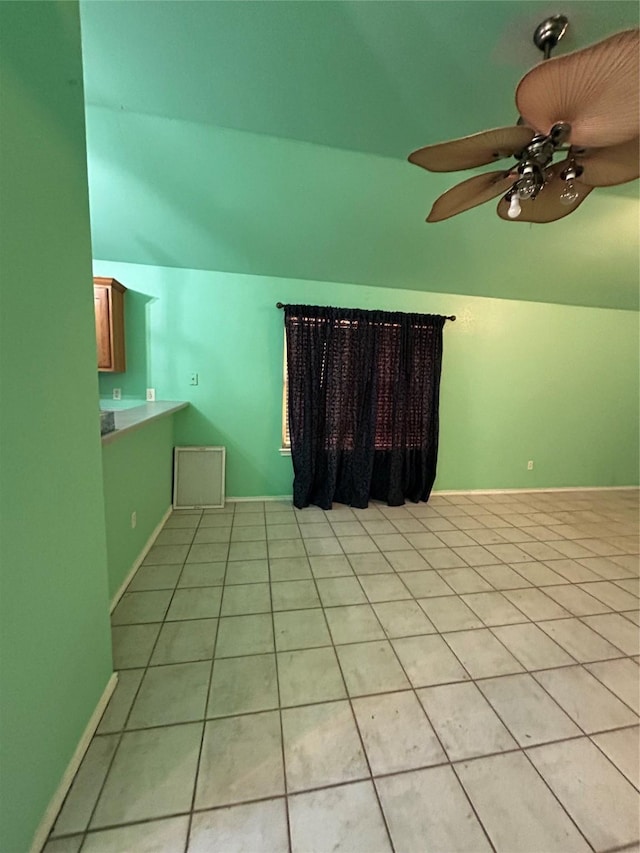 tiled empty room featuring ceiling fan