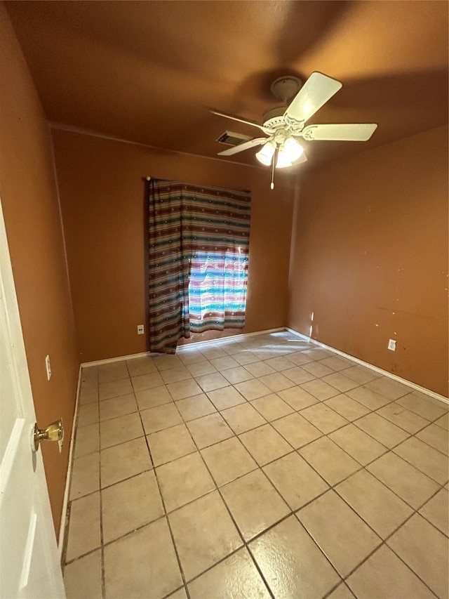 tiled empty room featuring ceiling fan