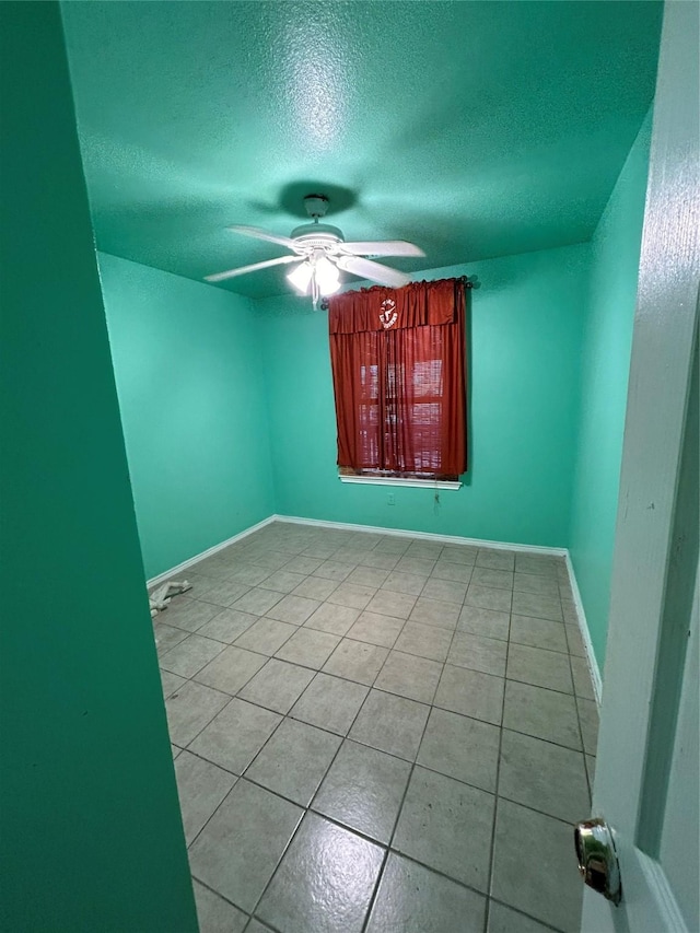 tiled spare room with a textured ceiling