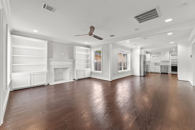 unfurnished living room with crown molding, sink, ceiling fan, and dark wood-type flooring