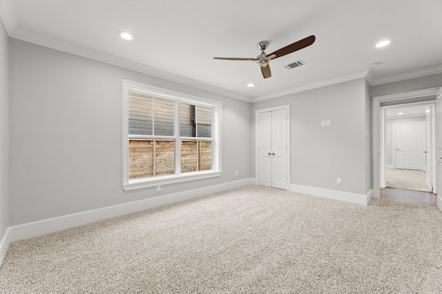 carpeted empty room featuring ceiling fan and crown molding