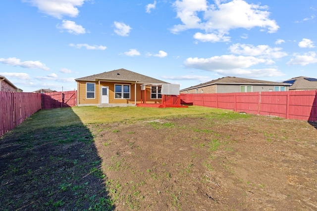 rear view of property featuring a lawn