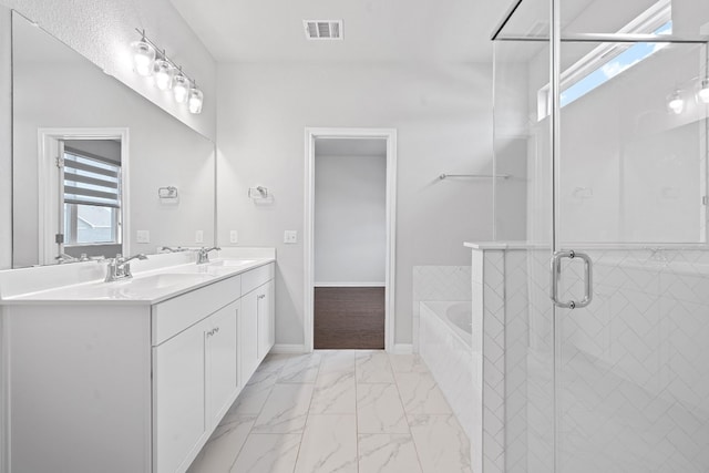 bathroom featuring shower with separate bathtub and vanity