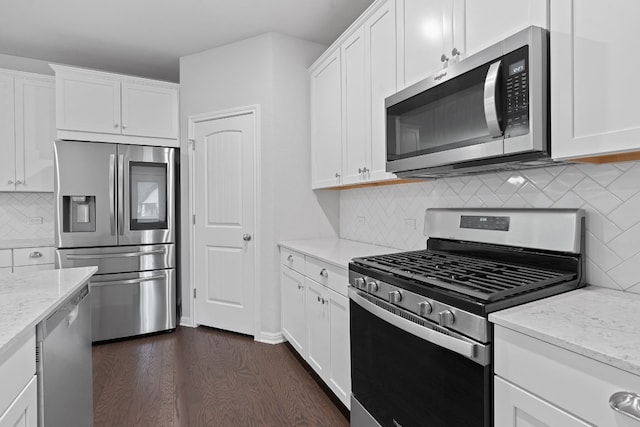 kitchen with white cabinetry, appliances with stainless steel finishes, light stone countertops, and backsplash