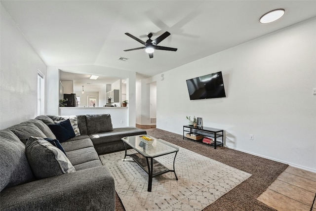 carpeted living room featuring ceiling fan and vaulted ceiling