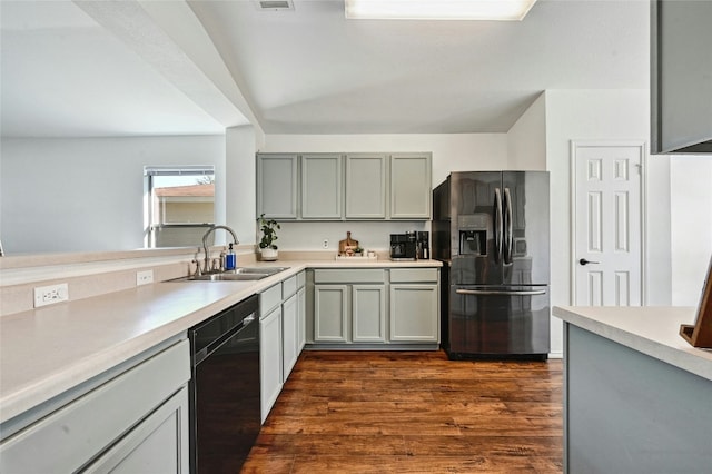 kitchen with gray cabinetry, sink, stainless steel fridge with ice dispenser, black dishwasher, and dark hardwood / wood-style floors