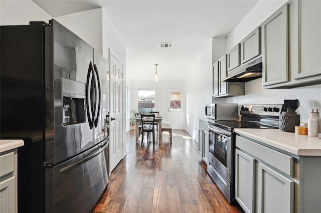 kitchen with gray cabinetry, pendant lighting, dark hardwood / wood-style floors, and appliances with stainless steel finishes