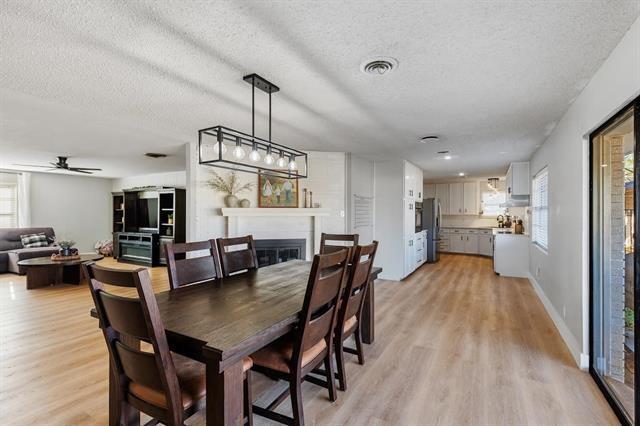 dining room with ceiling fan, light wood-type flooring, and a textured ceiling