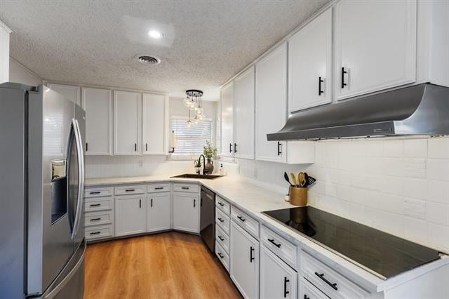 kitchen with white cabinets, appliances with stainless steel finishes, hanging light fixtures, and sink