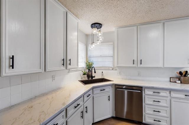 kitchen featuring white cabinets, sink, stainless steel dishwasher, decorative light fixtures, and light stone counters