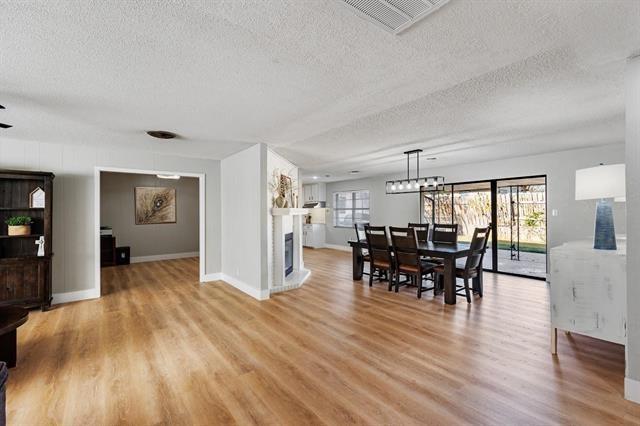 dining area featuring a textured ceiling and light hardwood / wood-style flooring