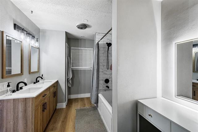 bathroom with shower / tub combo with curtain, vanity, wood-type flooring, and a textured ceiling