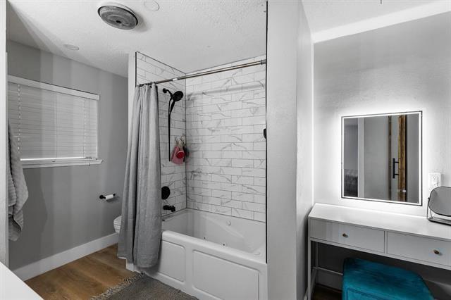 full bathroom with vanity, hardwood / wood-style flooring, toilet, and shower / bathtub combination with curtain