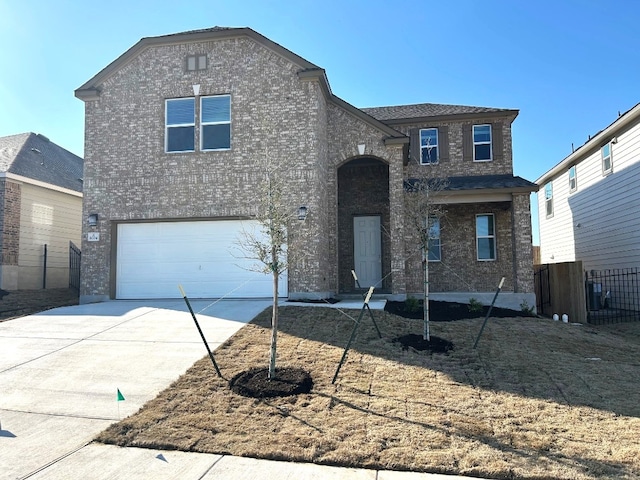 view of front of home featuring driveway, brick siding, an attached garage, and fence