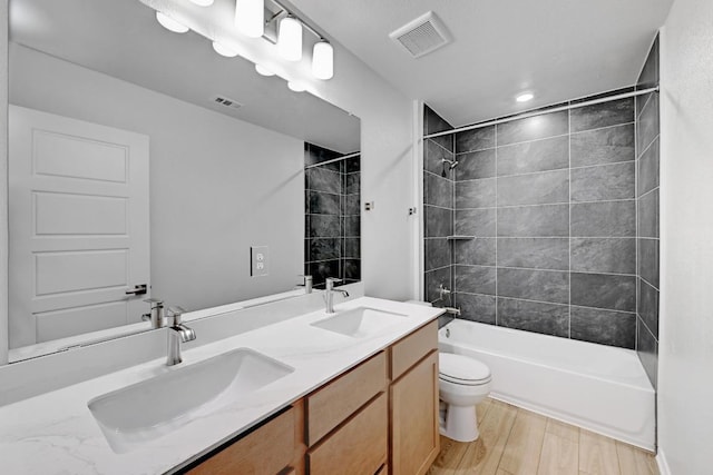8004 Tranquil Glade Trl, Austin, TX 78744 - full bath featuring toilet, shower / bathtub combination, double vanity, and wood finished floors