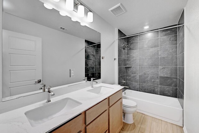8004 Tranquil Glade Trl, Austin, TX 78744 - bathroom featuring double vanity, shower / bathtub combination, and wood finished floors