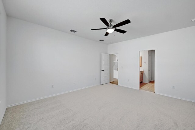 8004 Tranquil Glade Trl, Austin, TX 78744 - unfurnished bedroom with light colored carpet, connected bathroom, and ceiling fan