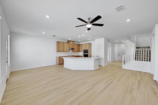 kitchen featuring ceiling fan, visible vents, open floor plan, and light wood finished floors