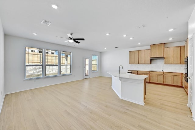 8004 Tranquil Glade Trl, Austin, TX 78744 - kitchen featuring stovetop, a ceiling fan, tasteful backsplash, open floor plan, and light wood finished floors