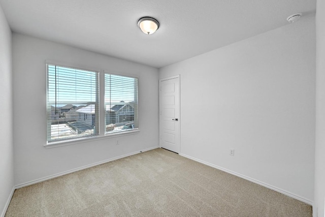 8004 Tranquil Glade Trl, Austin, TX 78744 - spare room with light colored carpet, baseboards, and a smoke detector