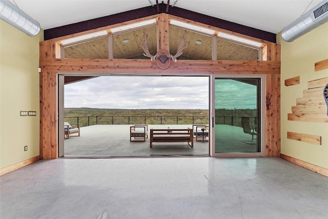 doorway with baseboards, lofted ceiling with beams, visible vents, and finished concrete floors