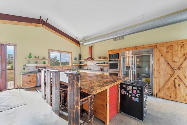 176 Elk Rdg, Canyon Lake, TX 78133 - kitchen featuring visible vents, black microwave, open shelves, wood counters, and wall chimney exhaust hood