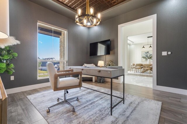 office with brick ceiling, an inviting chandelier, and hardwood / wood-style floors