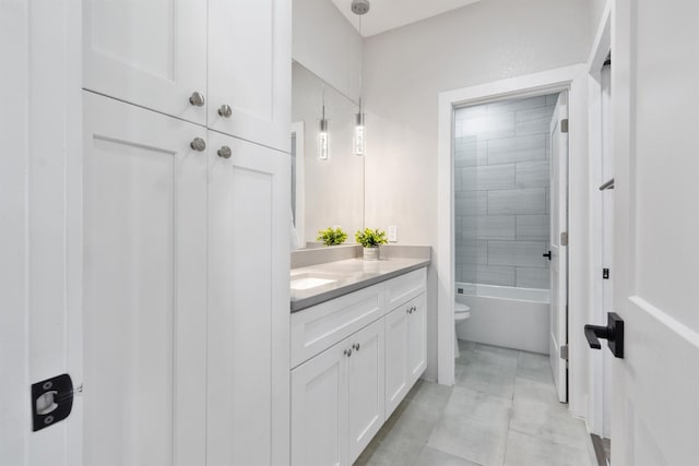 full bathroom featuring toilet, tiled shower / bath combo, and vanity