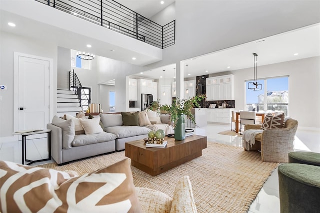 living room with a towering ceiling and a chandelier