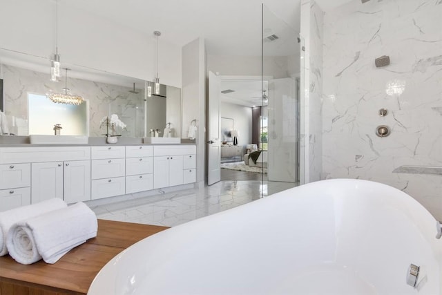 bathroom with double vanity, a freestanding tub, marble finish floor, ensuite bathroom, and walk in shower