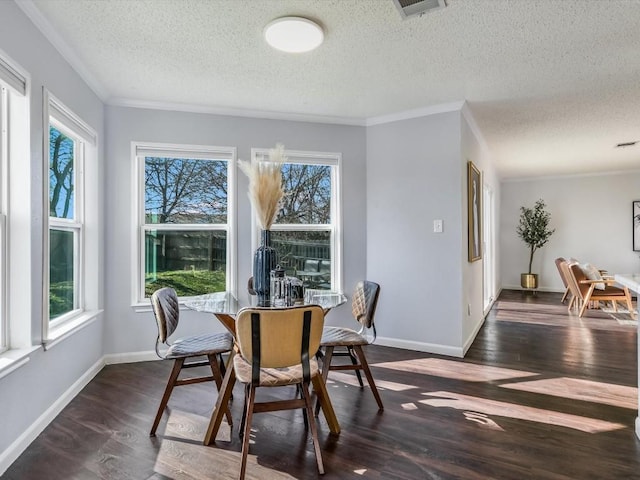 dining room featuring ornamental molding, dark wood-type flooring, and a wealth of natural light