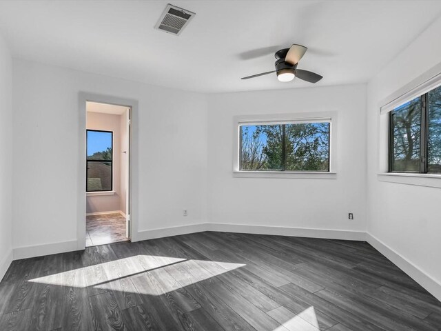 unfurnished room featuring ceiling fan, a healthy amount of sunlight, and dark hardwood / wood-style floors