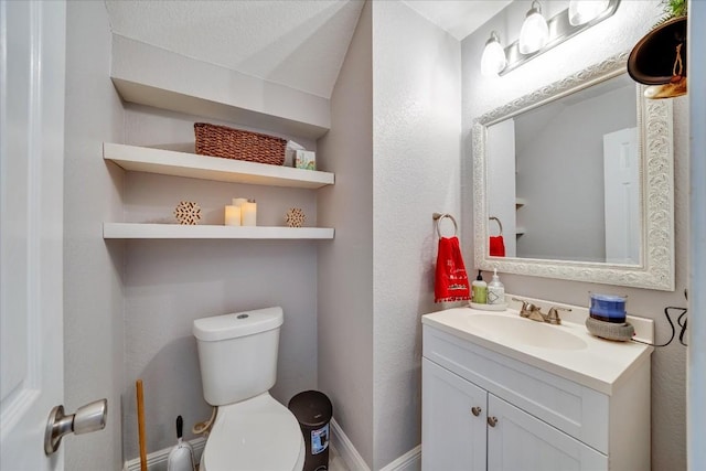 bathroom featuring vanity, a textured ceiling, and toilet