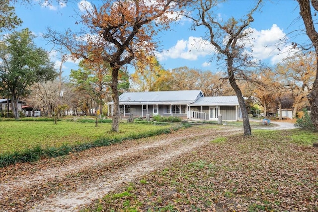 ranch-style home featuring covered porch and a front lawn