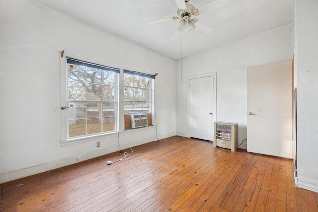 spare room featuring heating unit, light hardwood / wood-style flooring, ceiling fan, and cooling unit