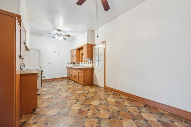 kitchen featuring range, ceiling fan, and sink