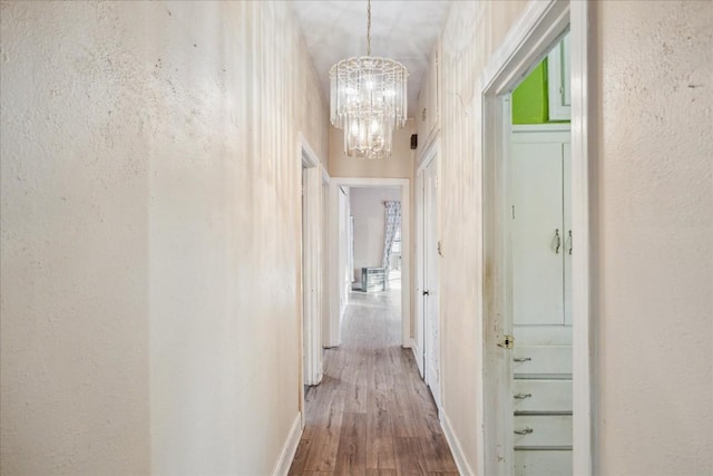 hall featuring hardwood / wood-style floors and a chandelier