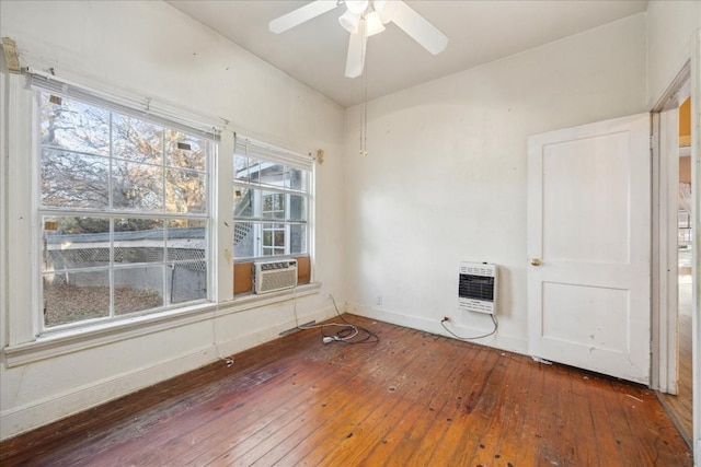 empty room featuring hardwood / wood-style flooring, ceiling fan, cooling unit, and heating unit