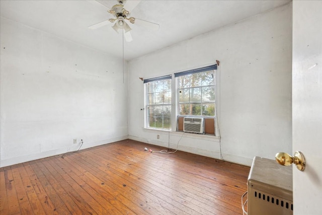 empty room with hardwood / wood-style floors, ceiling fan, and cooling unit