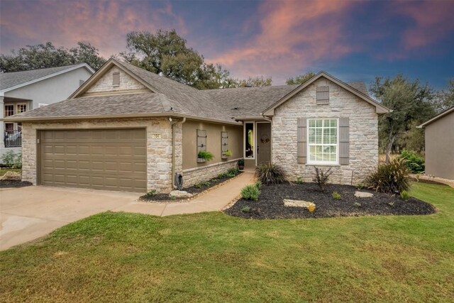 single story home with a garage and a yard