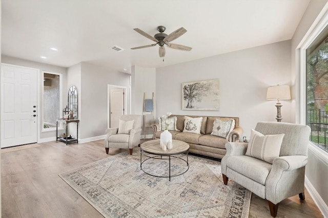 living room featuring hardwood / wood-style flooring, ceiling fan, and a healthy amount of sunlight