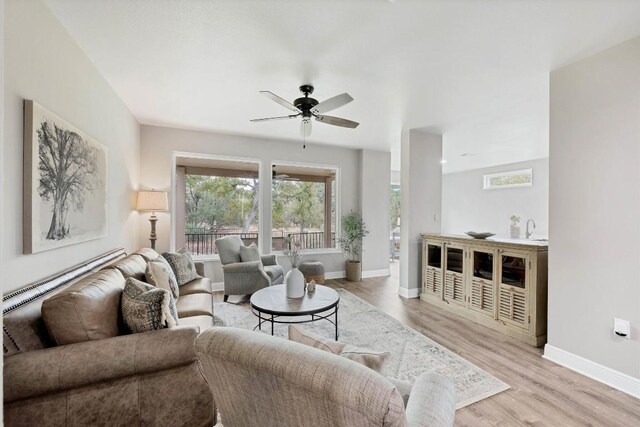 living room featuring ceiling fan and light hardwood / wood-style flooring