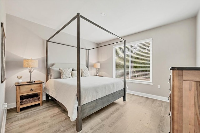 bedroom with light wood-style flooring and baseboards